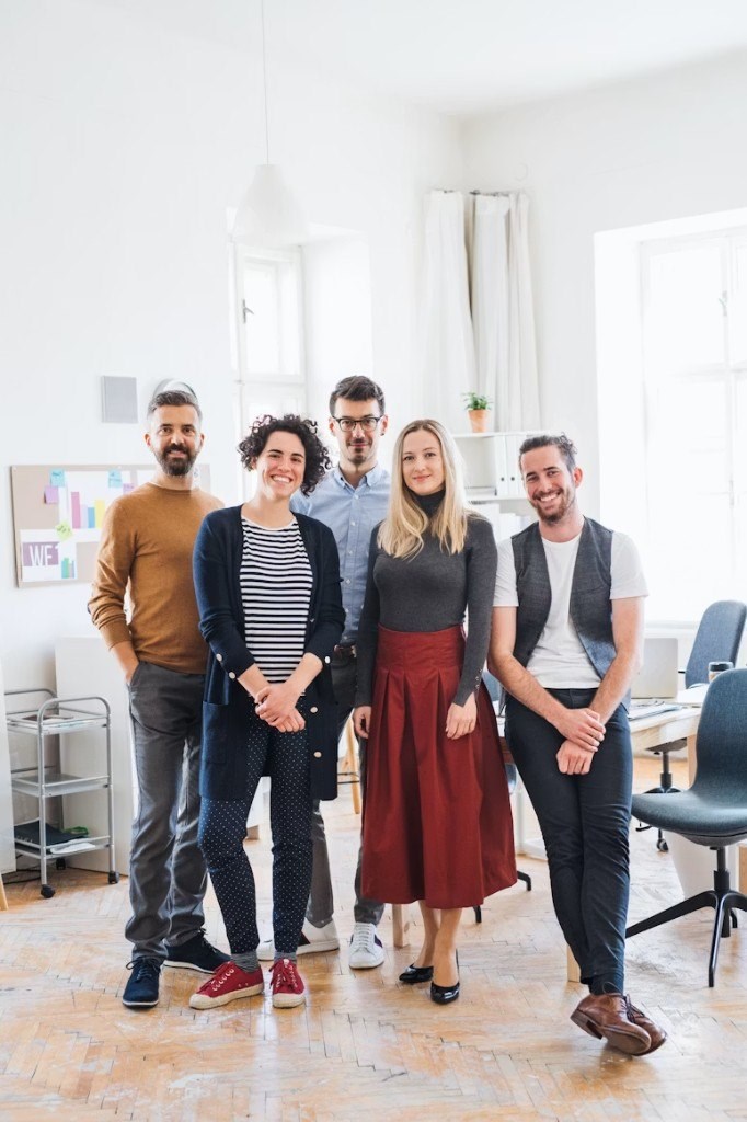 AD Works team standing together in a bright modern office